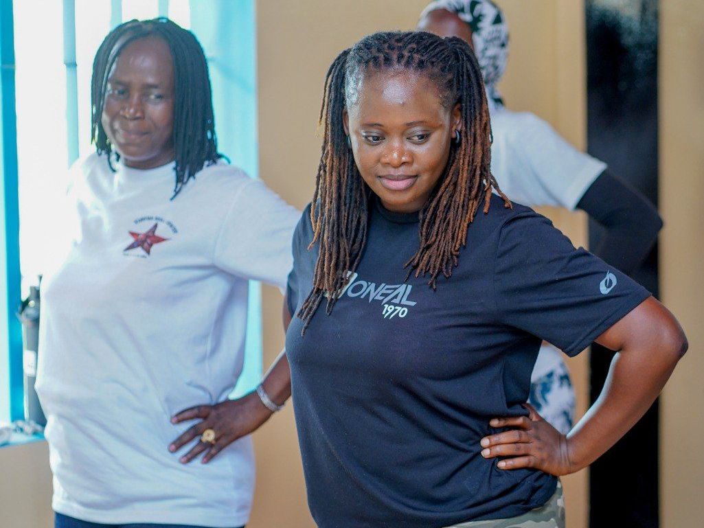 Two women are standing next to each other with their hands on their hips.