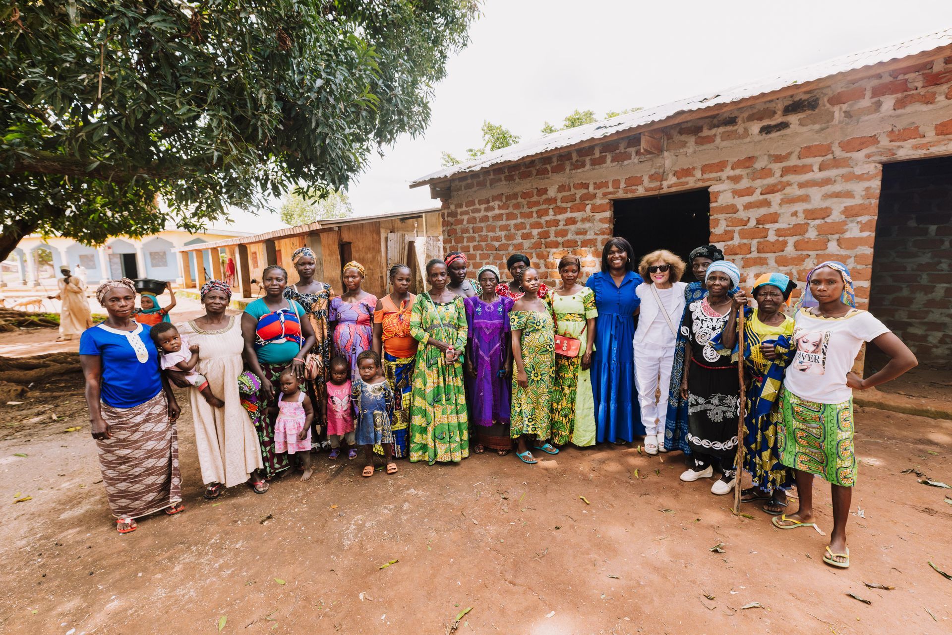 A group of people are posing for a picture in front of a brick building.
