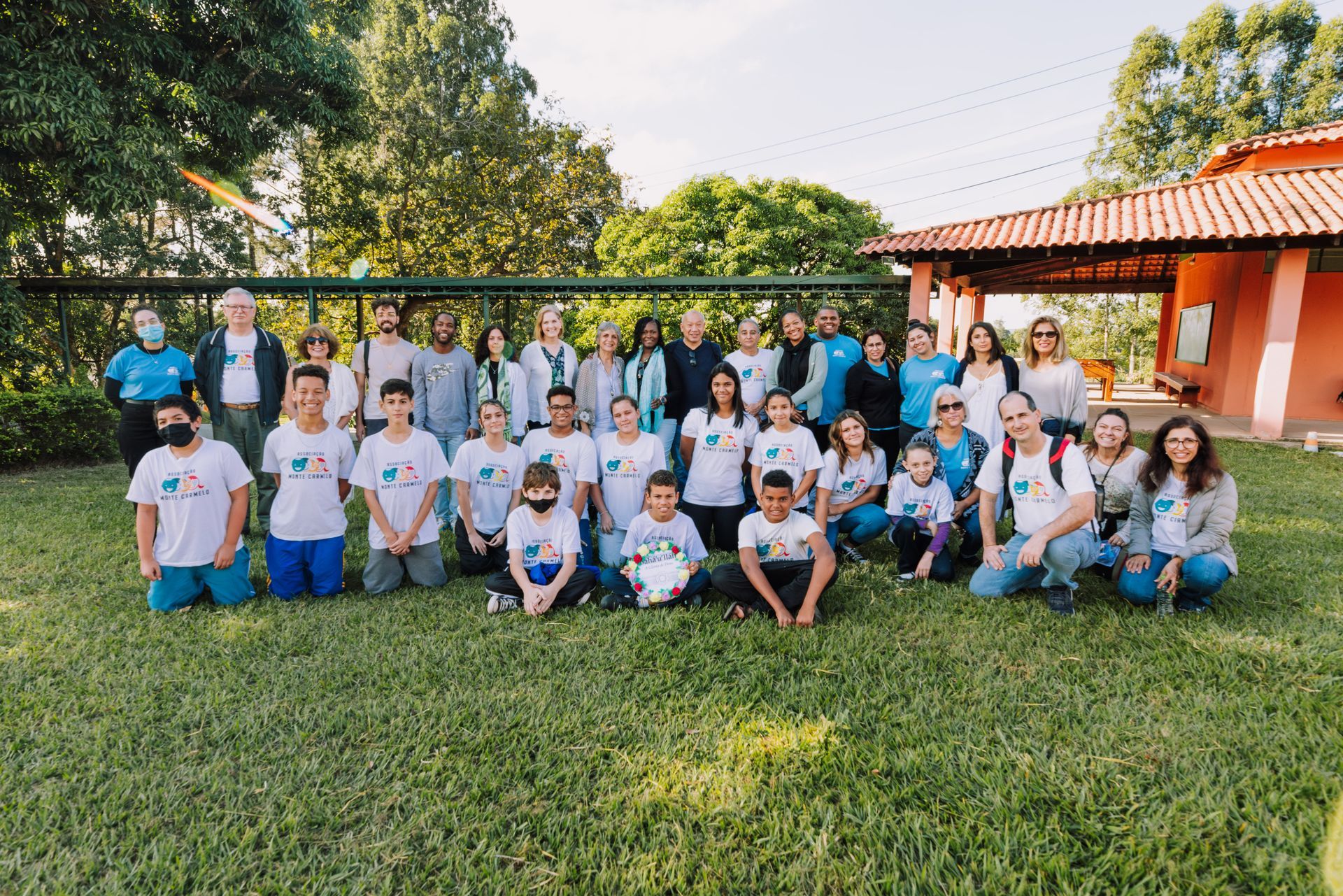 A large group of people are posing for a picture in the grass.