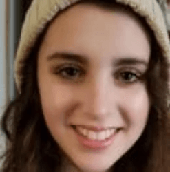 A close up of a woman wearing a beanie and smiling.