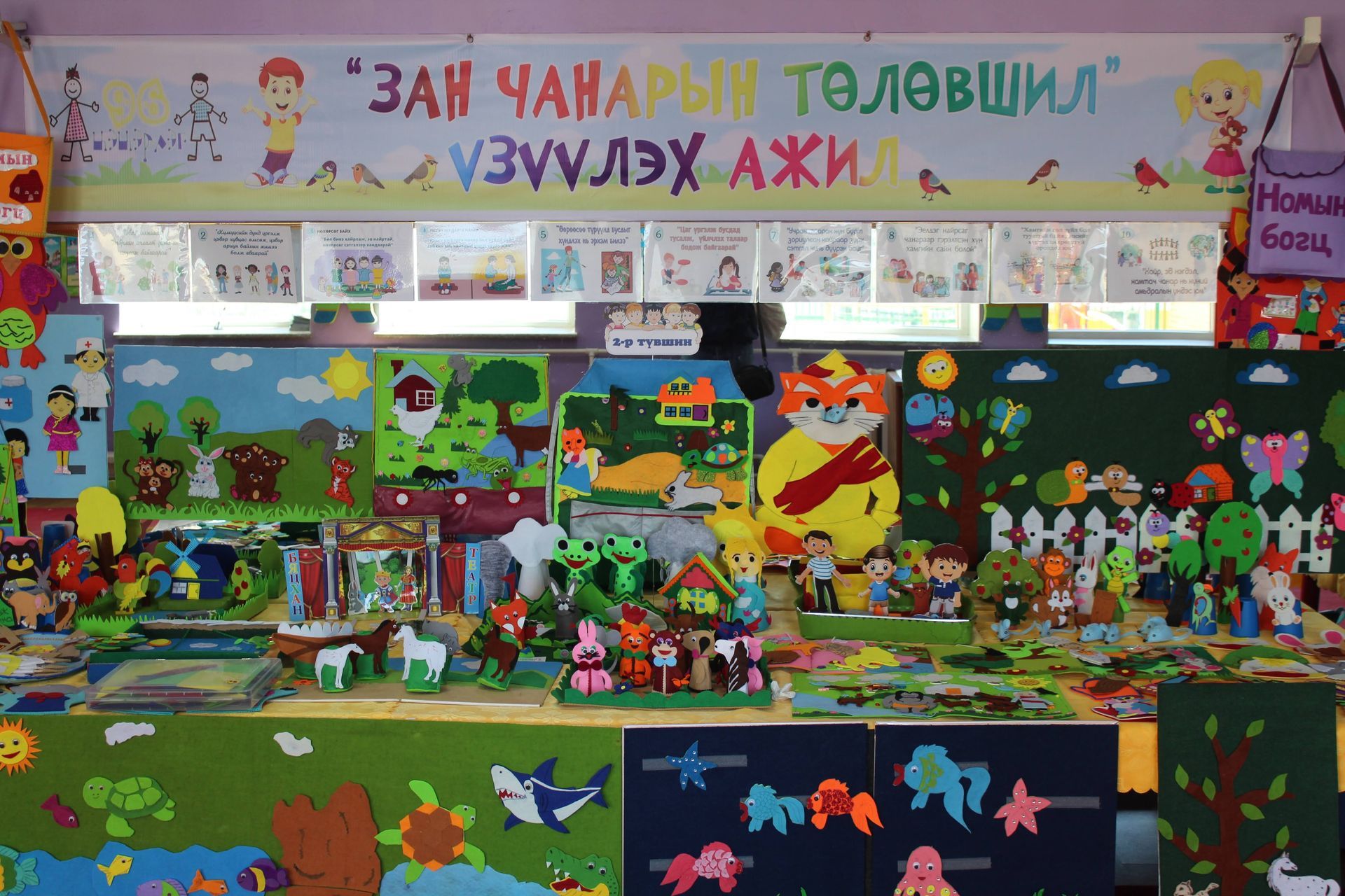 Colorful wall of artwork and learning activities for Kindergarteners, includes different animals, insects, people, etc. 