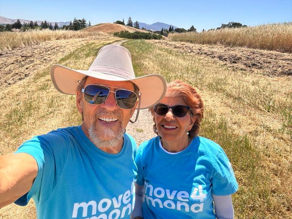 A man and a woman are taking a selfie in a field.