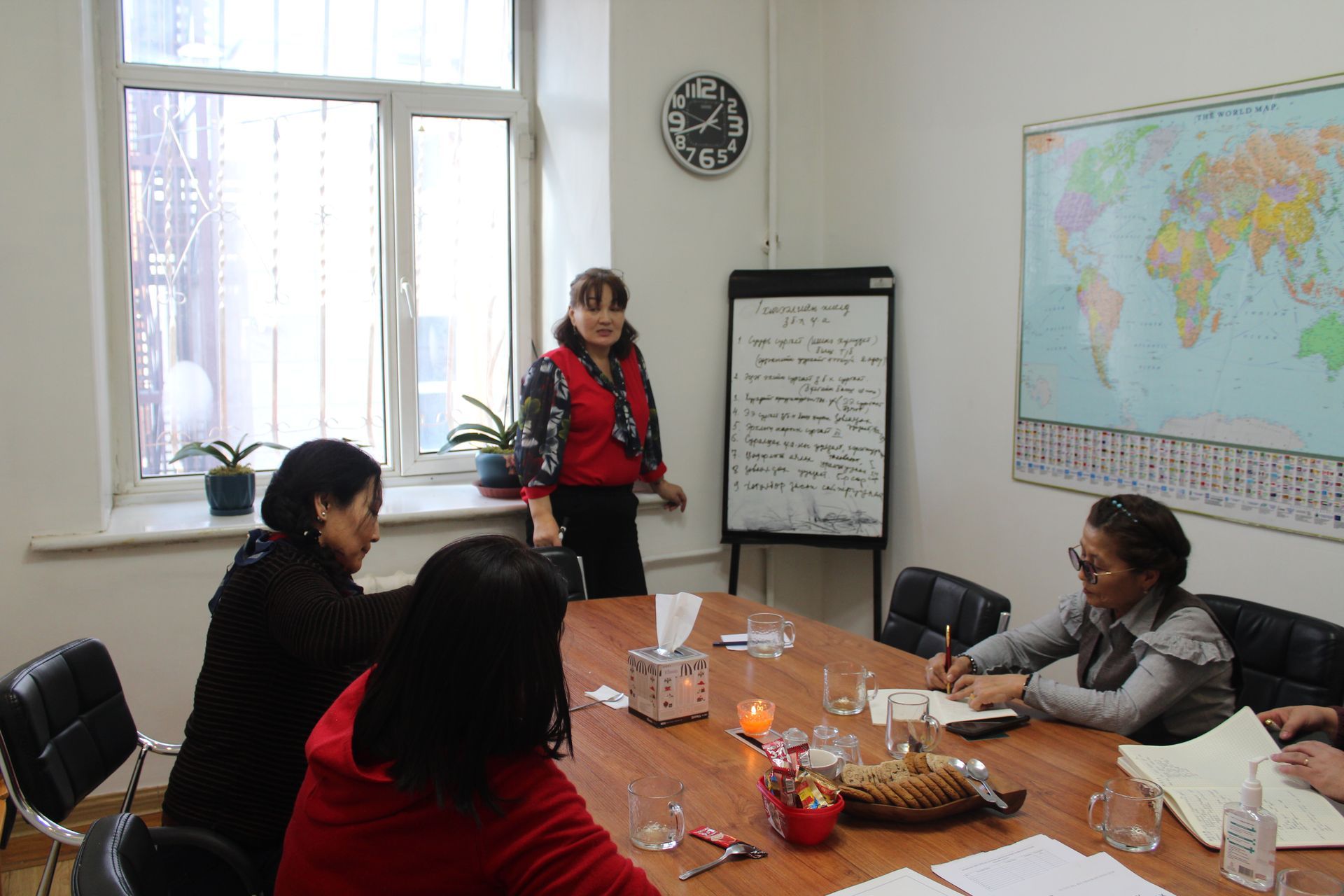Four main facilitators gathered to talk about ongoing activities, taking notes on a whiteboard.