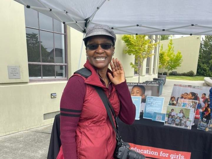 A woman standing in front of a table that says education for girls