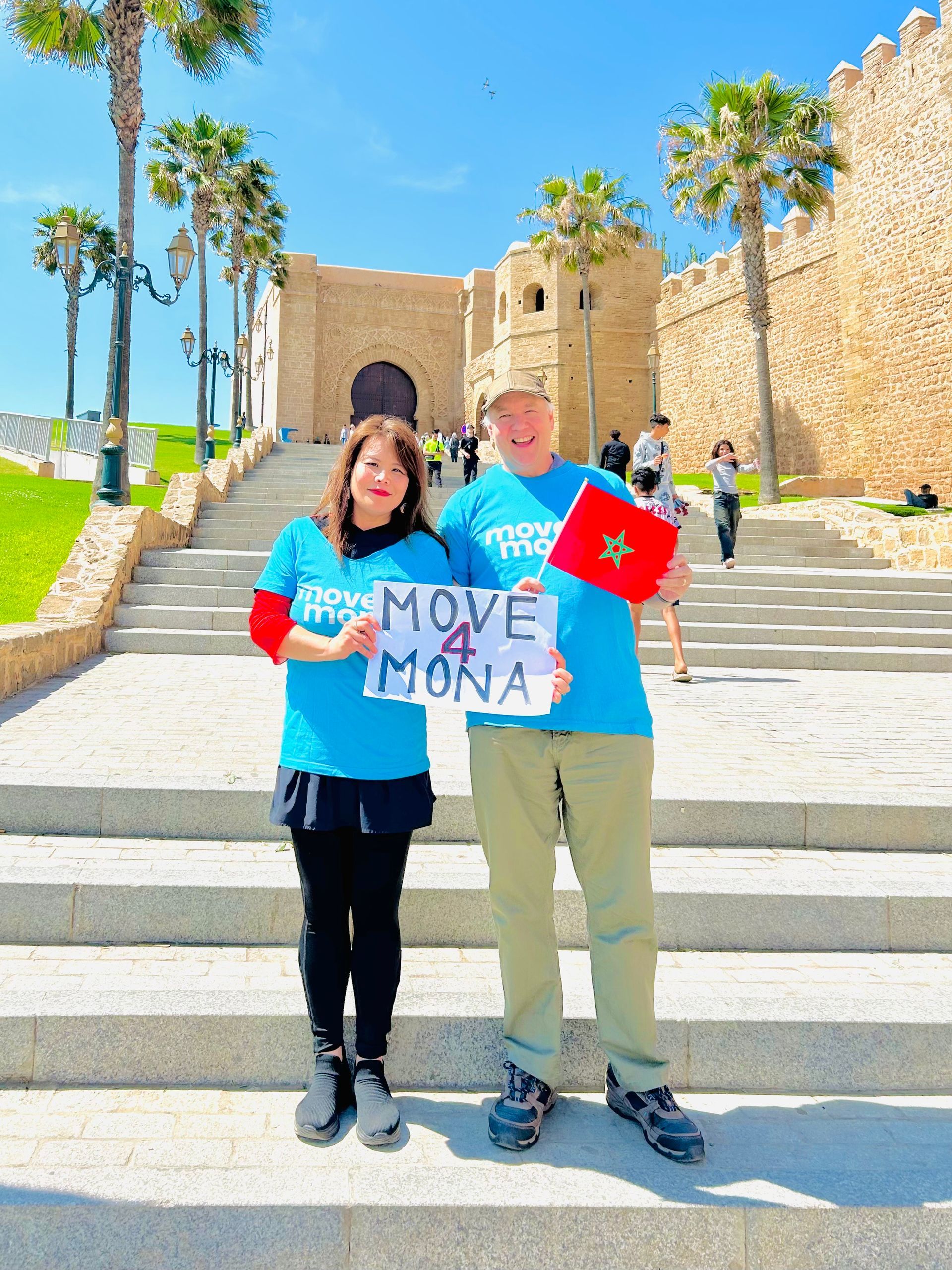 A man and a woman are holding a sign that says move mona