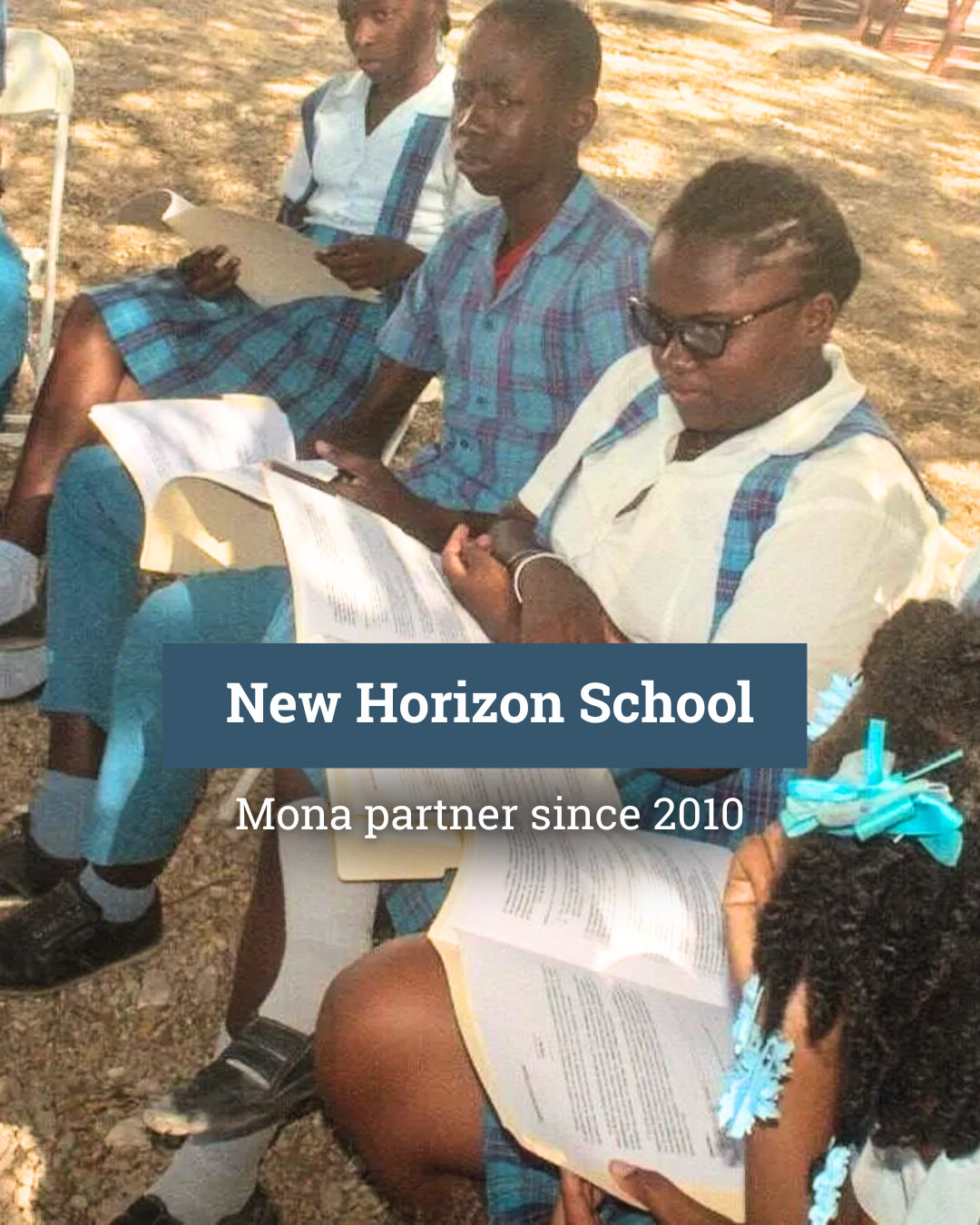 A group of children in school uniforms are sitting on the ground