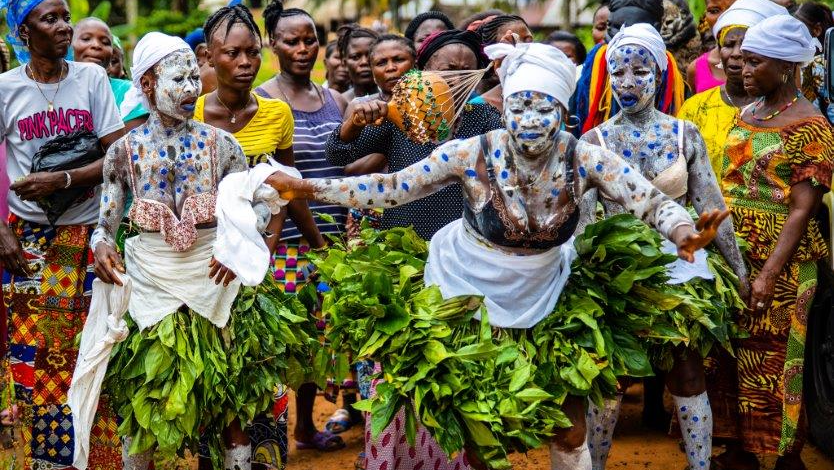 A group of women are dancing in front of a crowd of people.