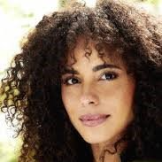 A close up of a woman 's face with curly hair.