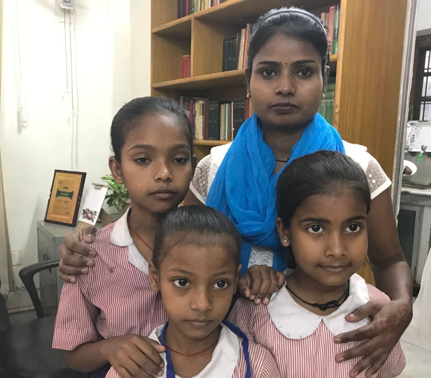 A group of young girls are posing for a picture with their mother