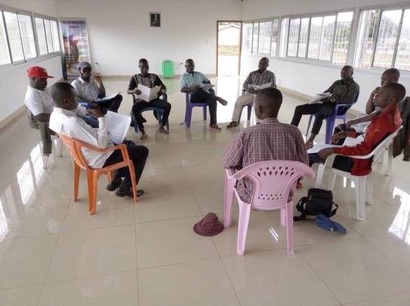 A group of people are sitting in a circle in a room.