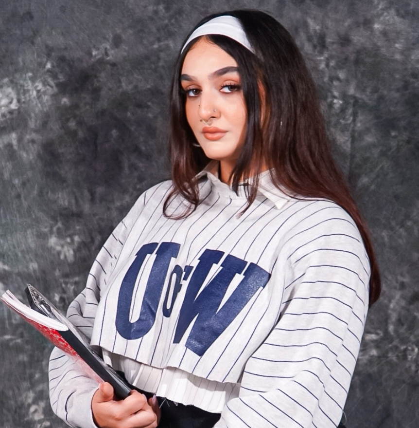 A woman wearing a striped shirt with the word uw on it