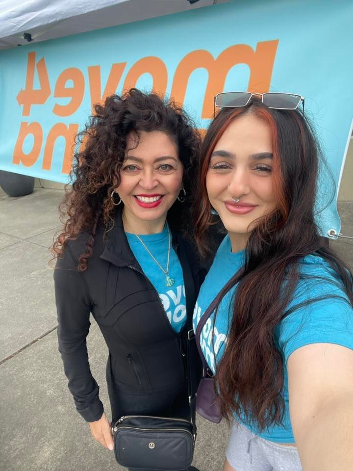Two women are posing for a selfie in front of a sign that says 49