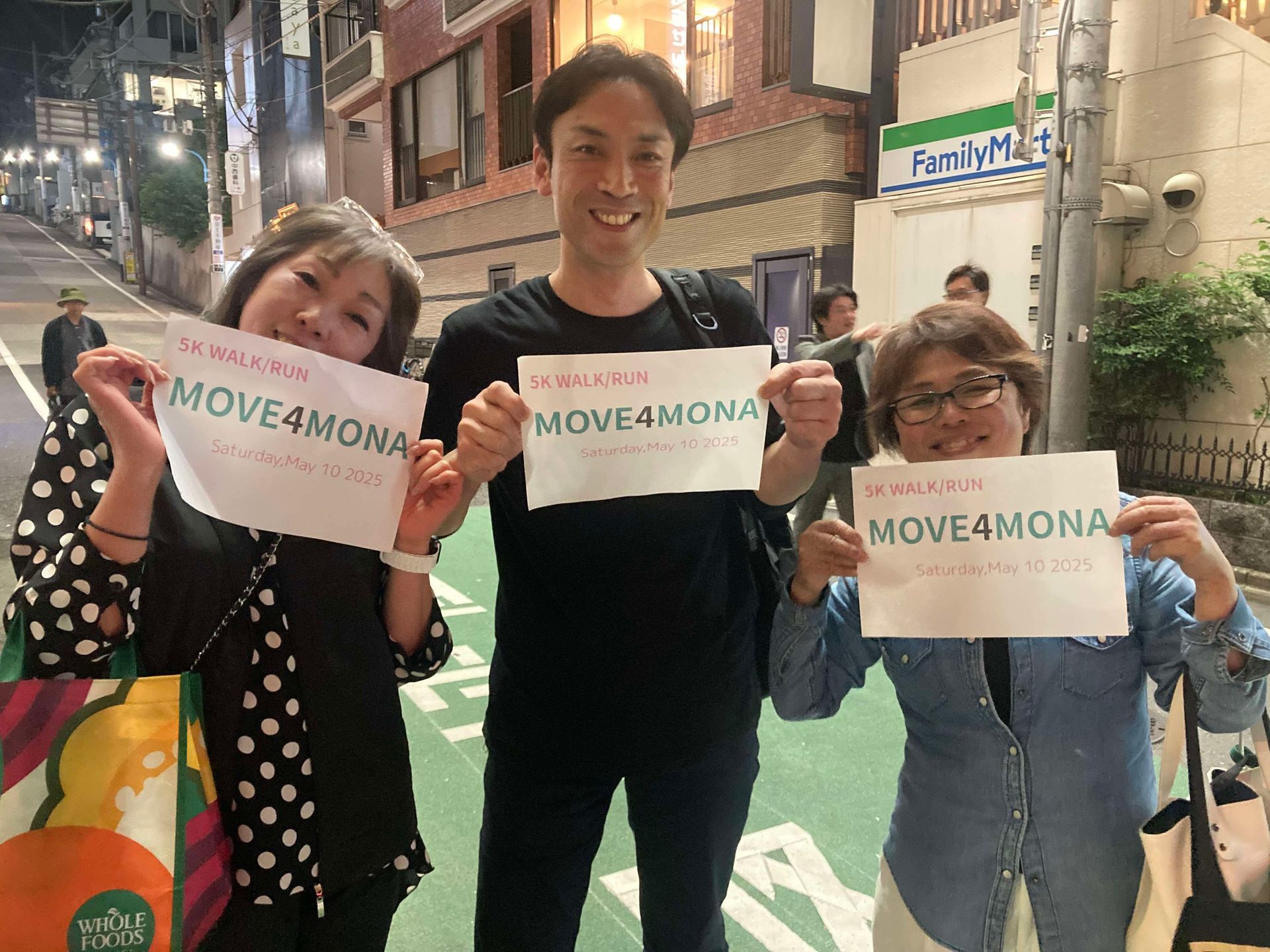 A group of people are holding up signs that say move 4 mona.