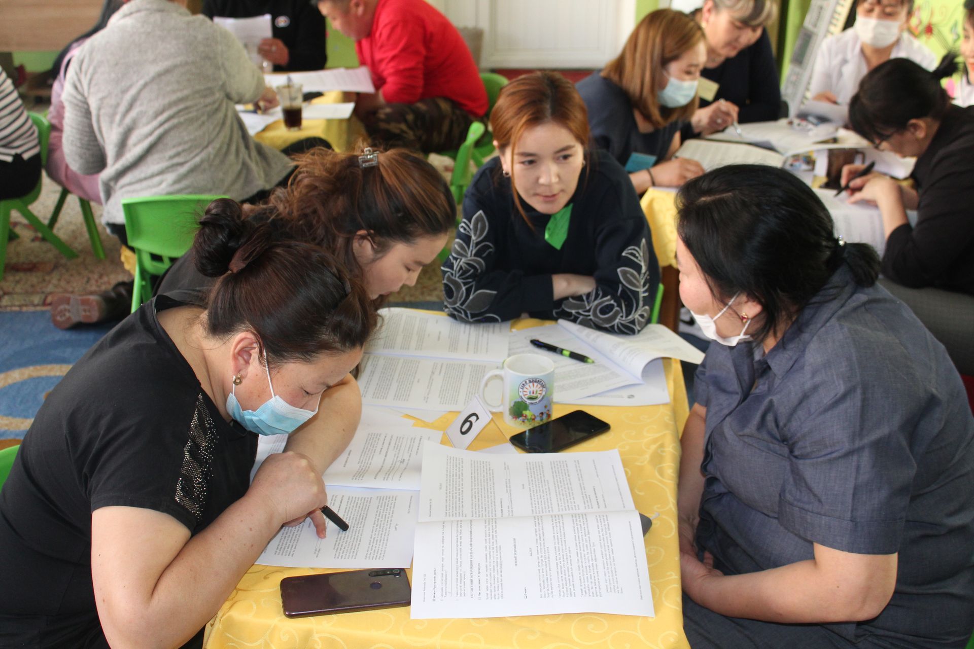 Four staff members sitting at a table together receiving their teacher training.