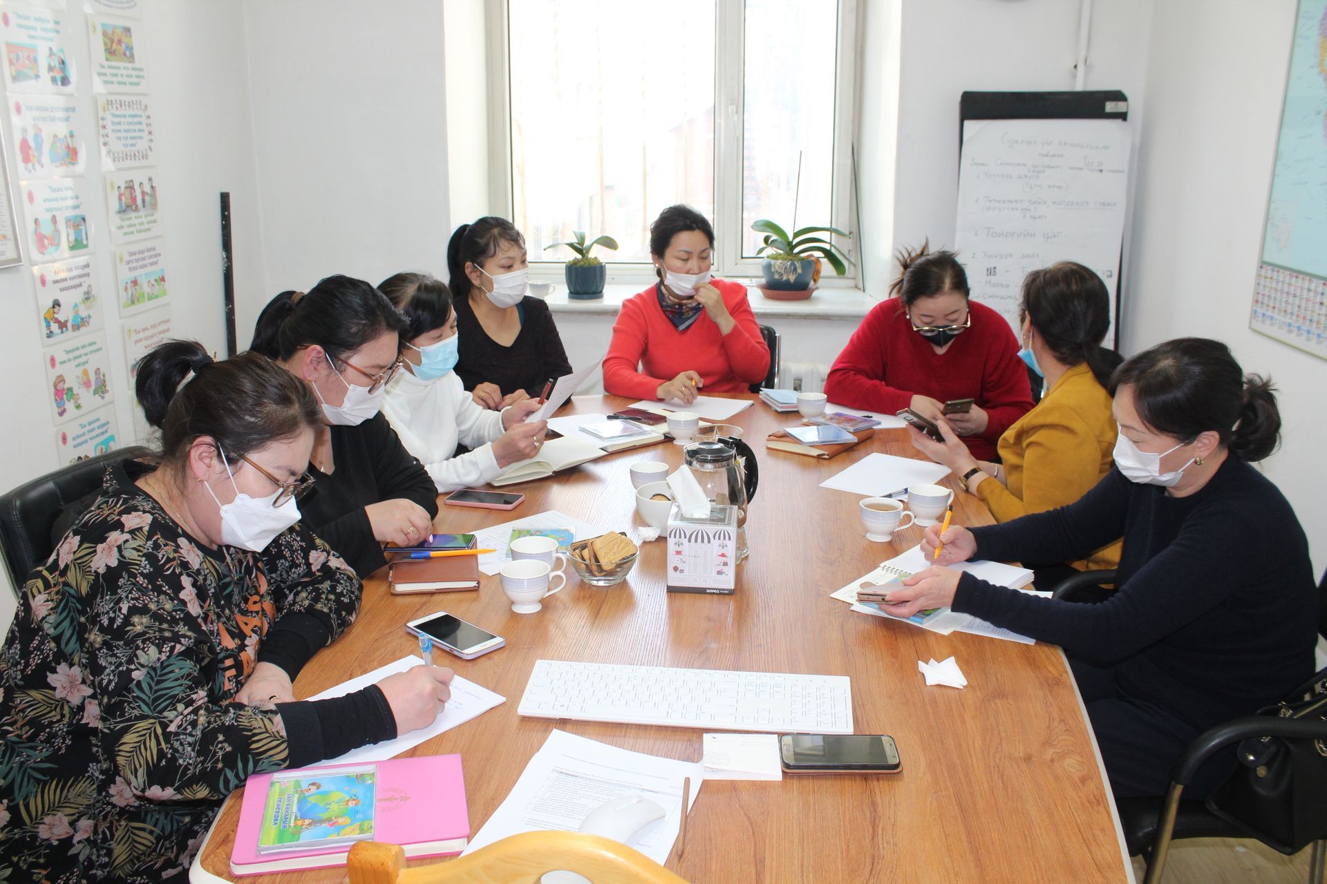 A group of kindergarten teachers sitting at a table engaging in a facilitated training session.   