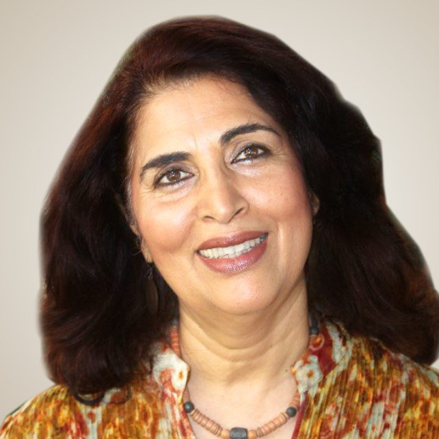 A woman with long hair is smiling and wearing a necklace
