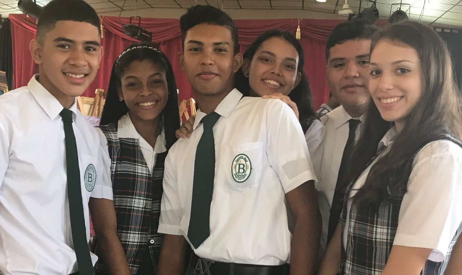 A group of young people in school uniforms are posing for a picture.