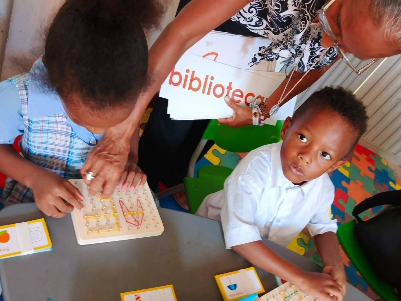A woman is holding a sign that says biblioteca