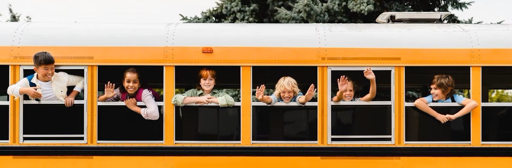 A group of children are looking out of the windows of a school bus.
