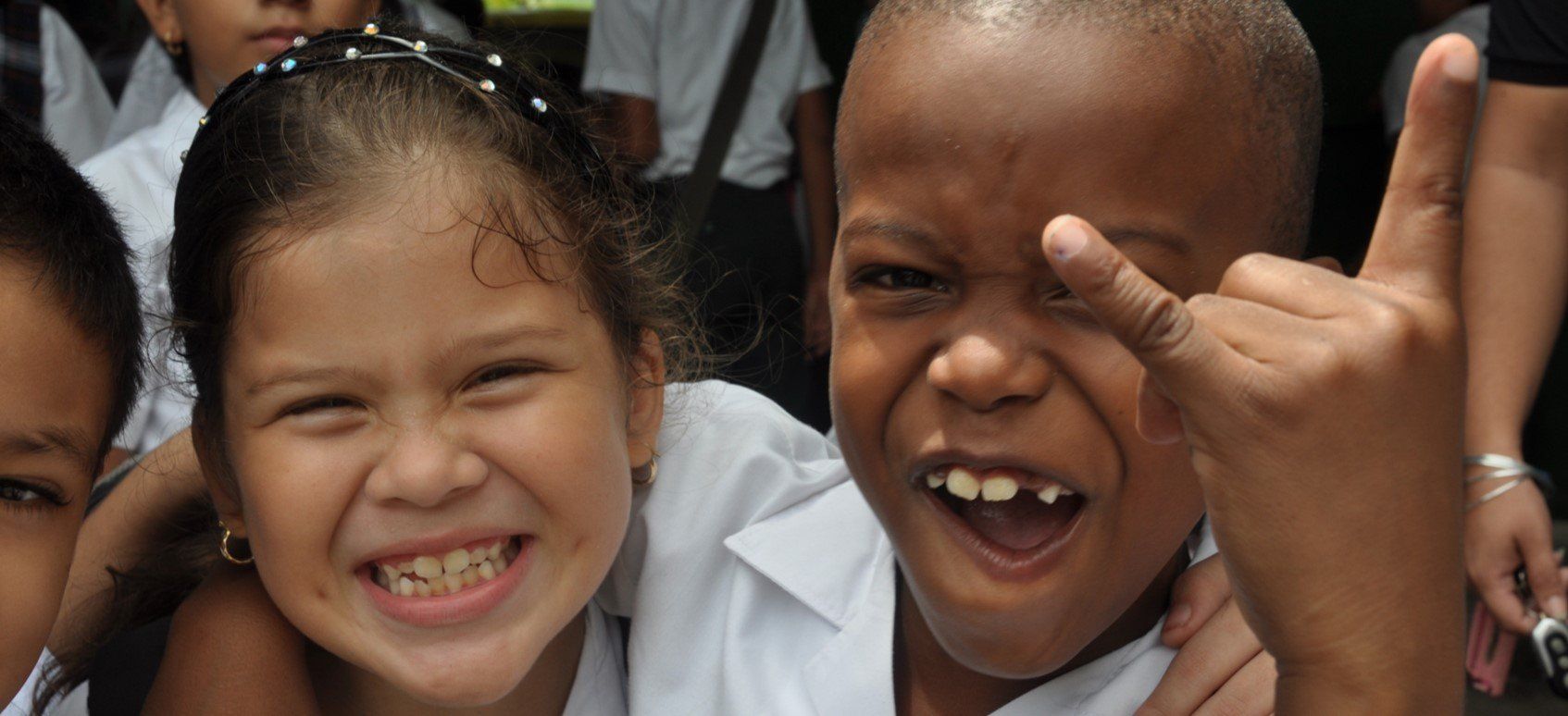 A group of children are smiling and making funny faces.