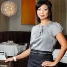 A woman is standing in a restaurant with her hands on her hips.