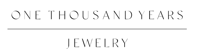 A logo for one thousand years jewelry is shown on a white background.