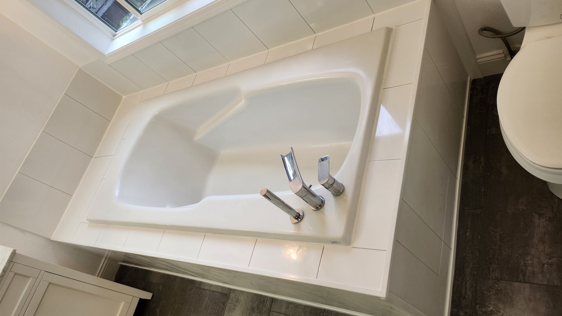 A bathtub in a bathroom next to a toilet.