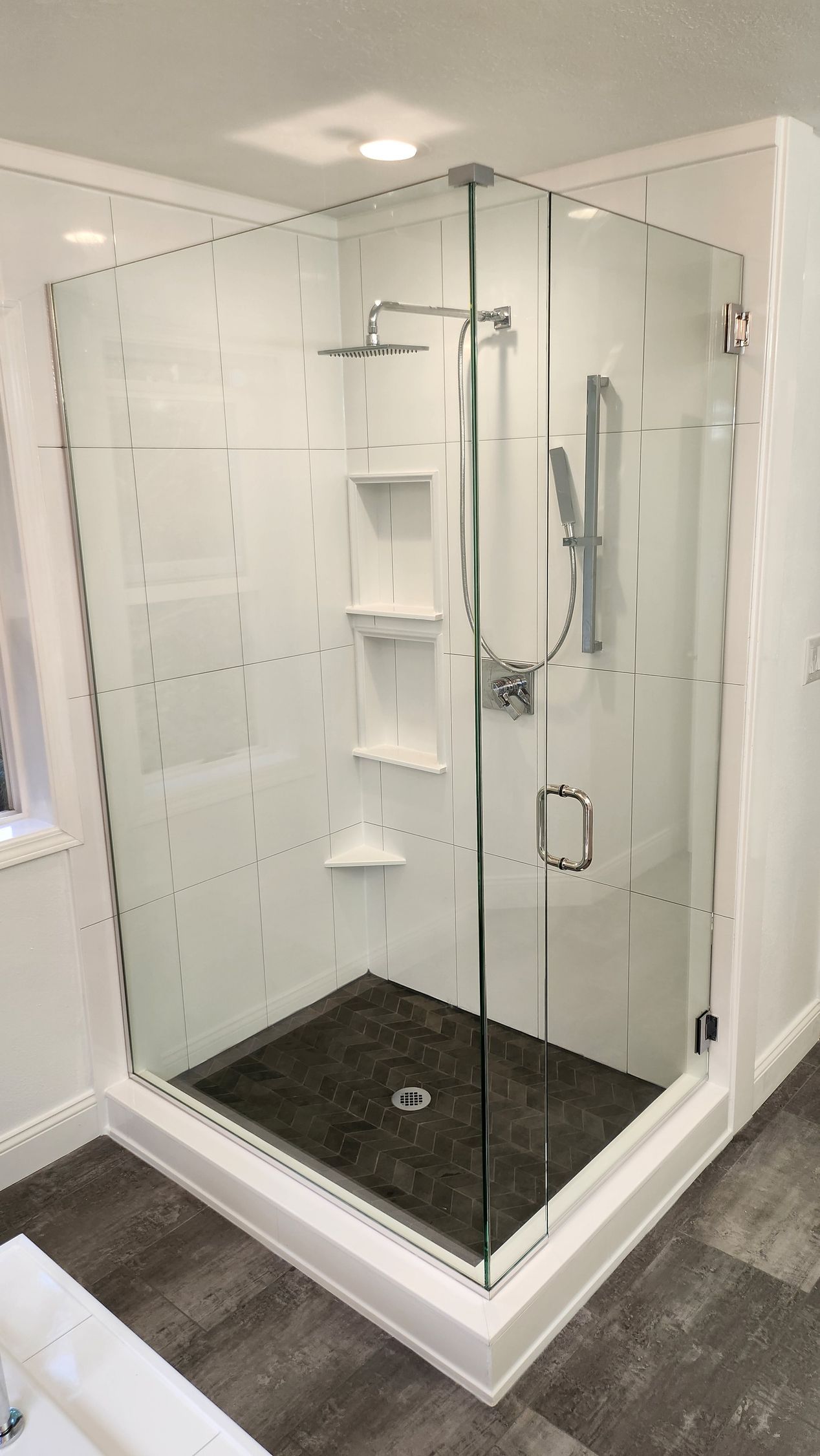 A bathroom with a walk in shower with a glass door.