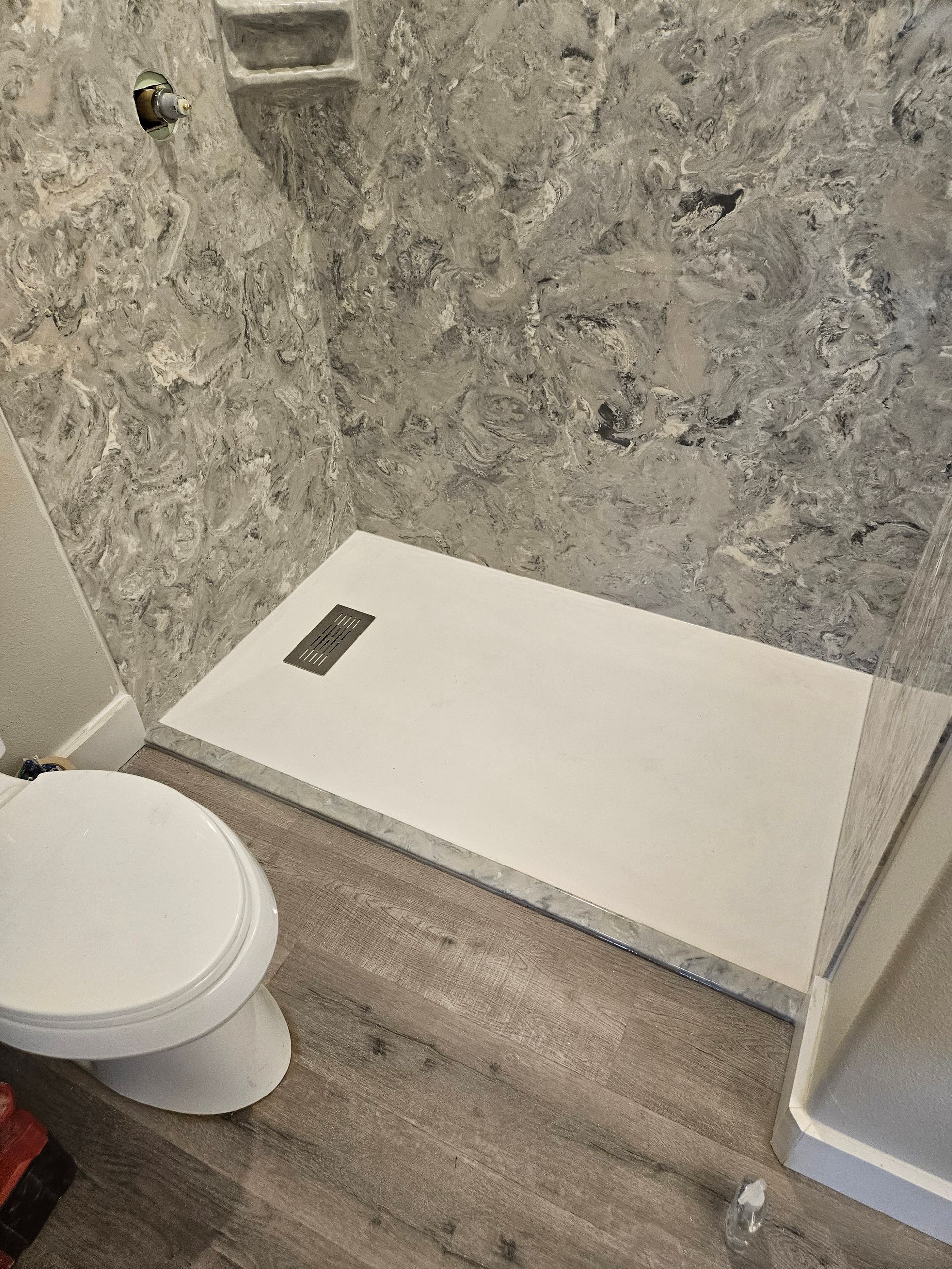A bathroom with a toilet and a shower stall.