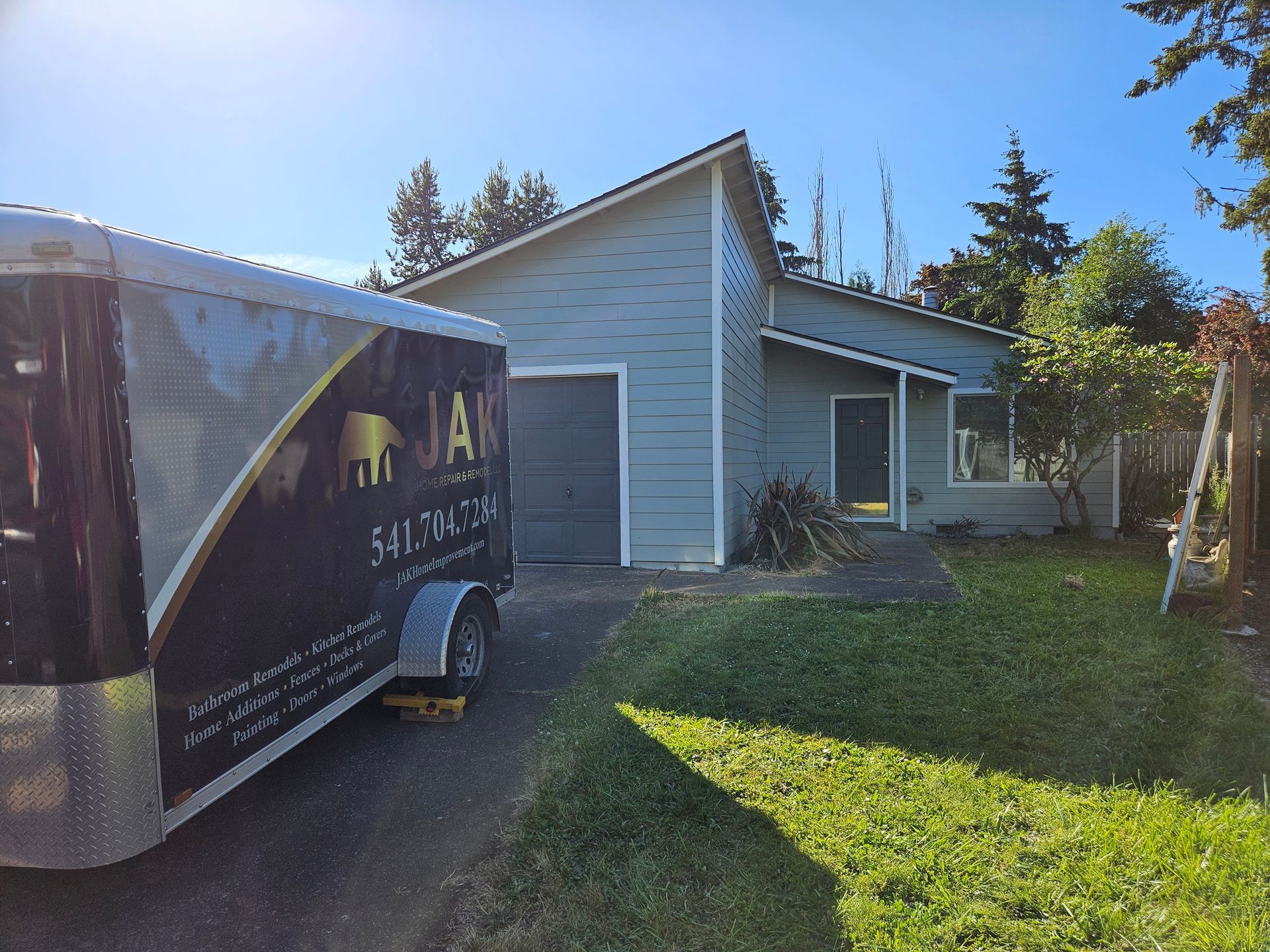 A trailer is parked in front of a house.