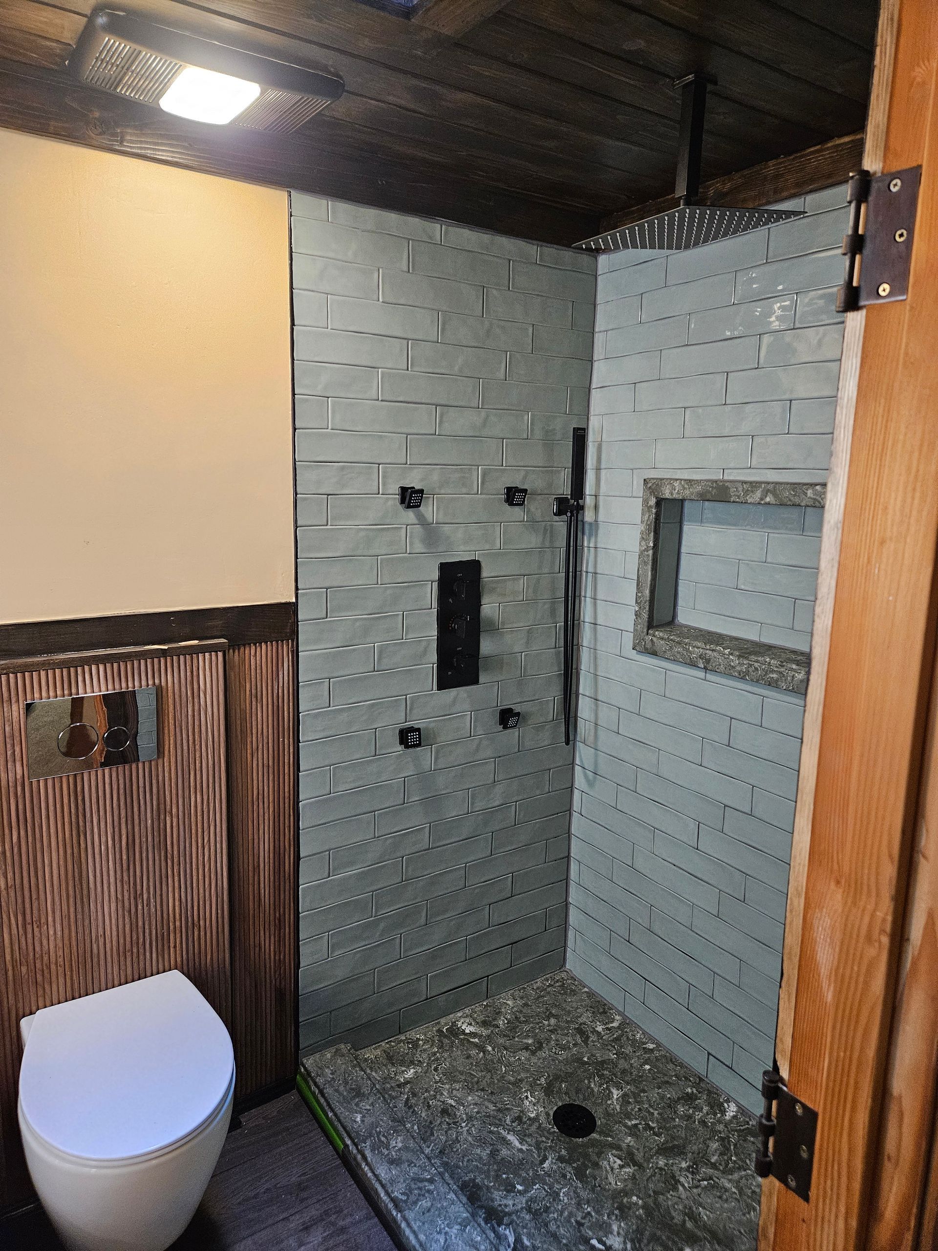 A bathroom with a toilet and a walk in shower.