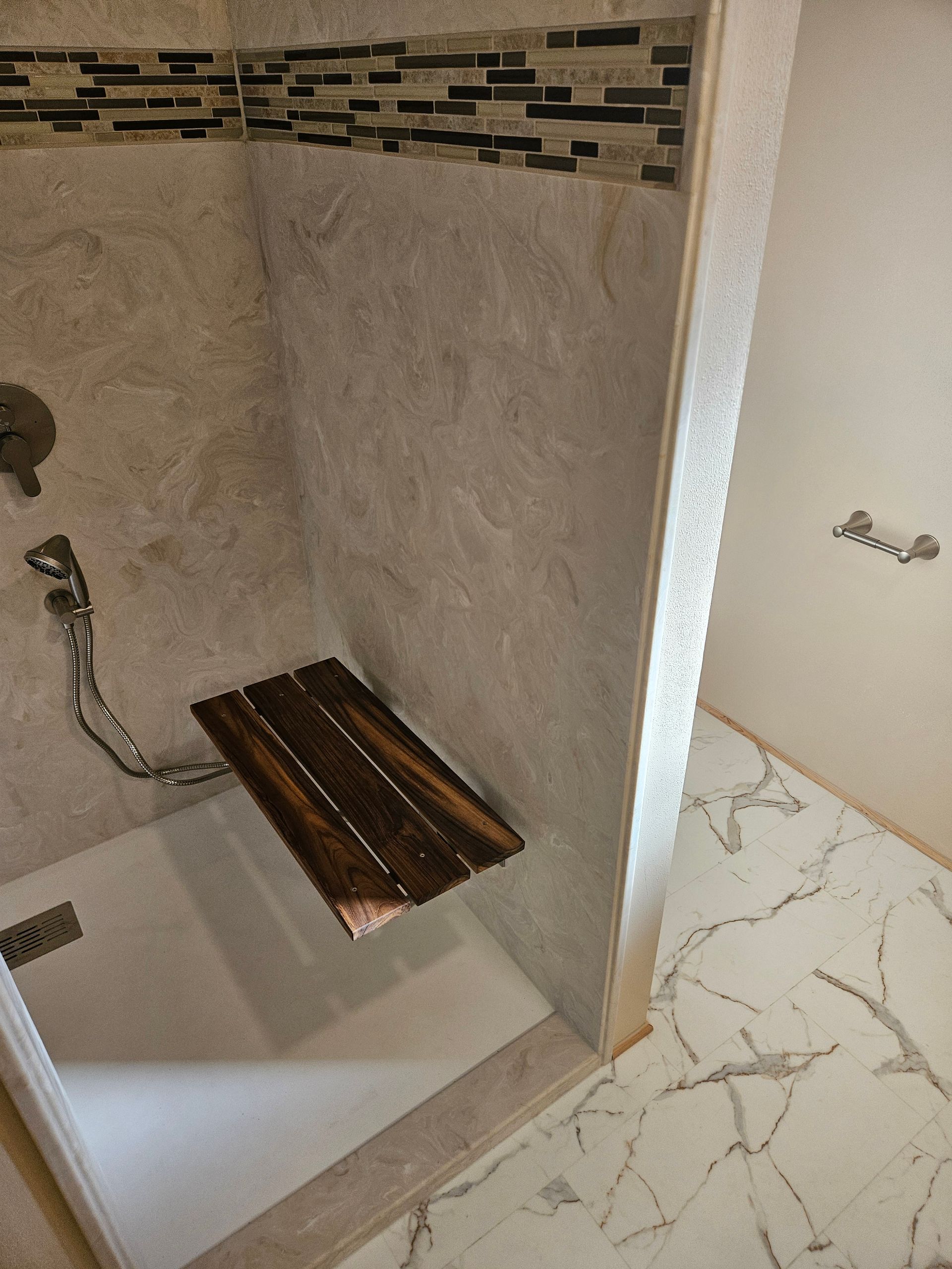 A shower with a wooden seat in it