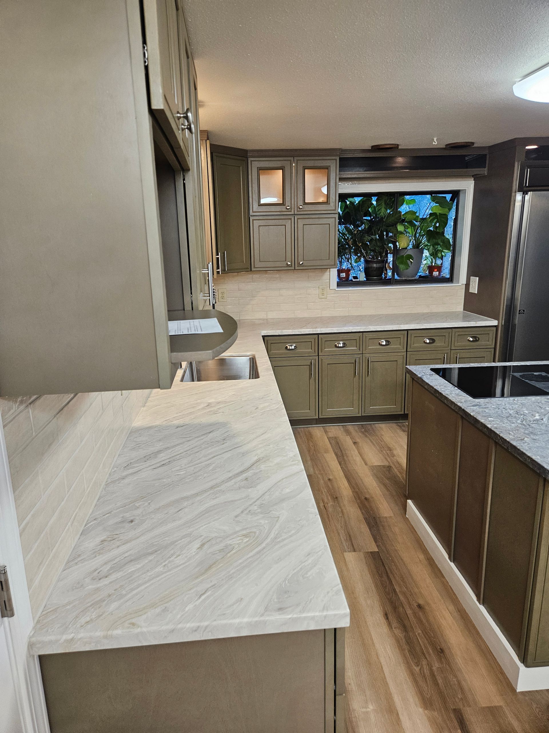 A kitchen with a sink , stove , and a window.