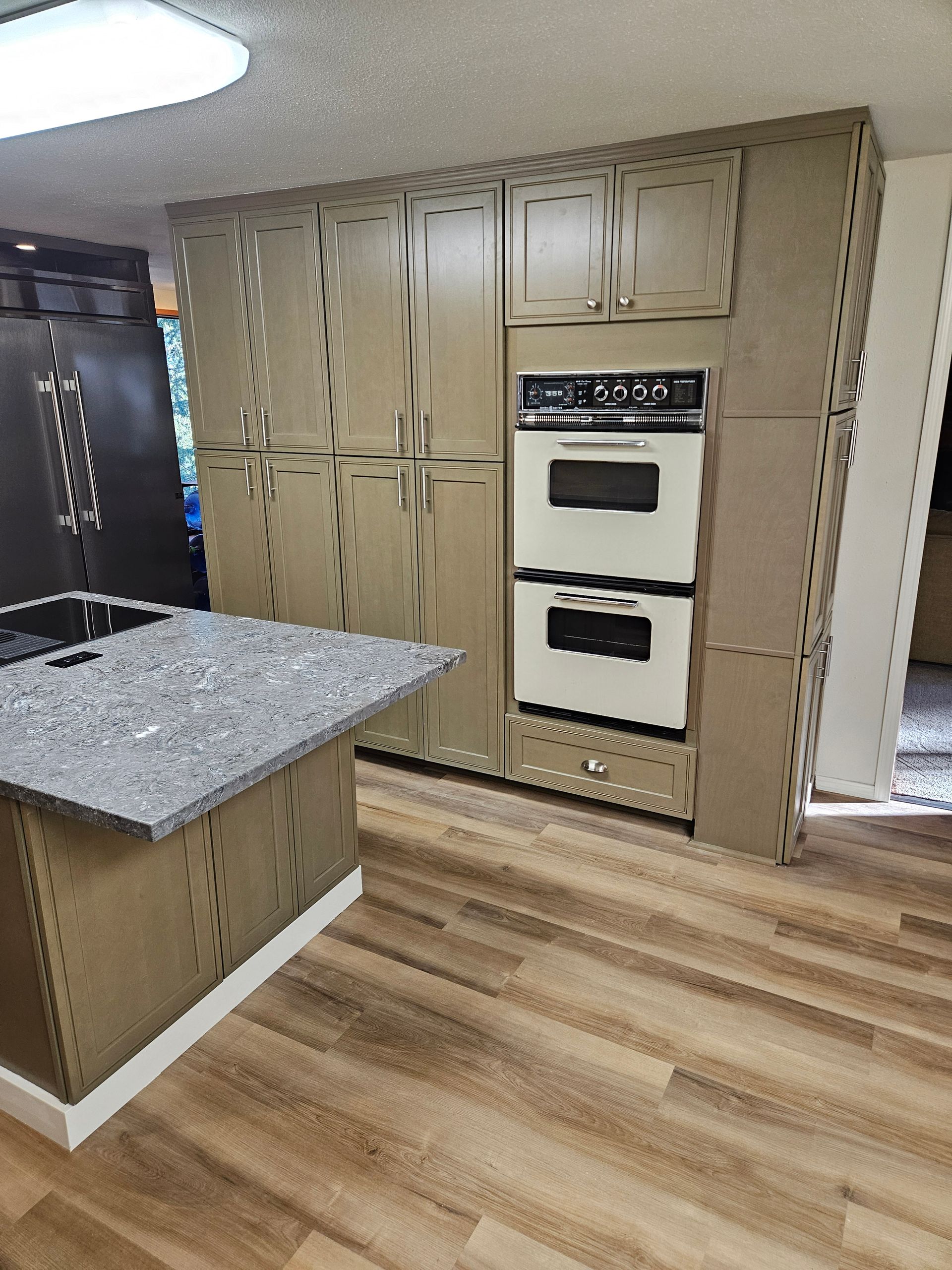 A kitchen with a double oven and a refrigerator.