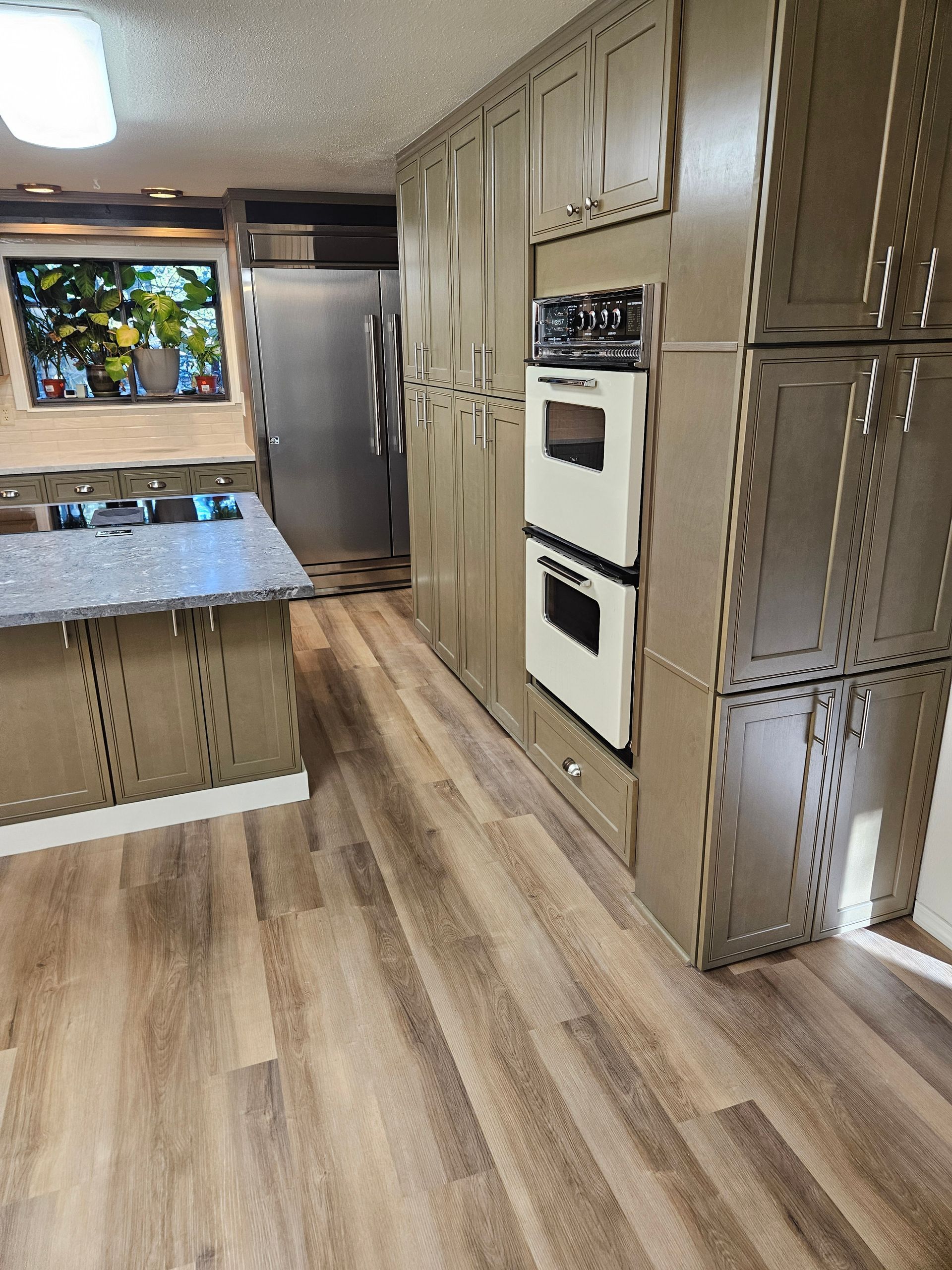 A kitchen with wooden floors and stainless steel appliances.