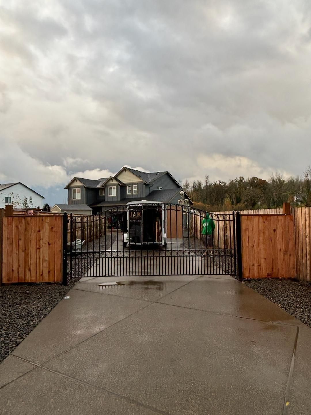 A house with a trailer parked in front of it behind a gate.