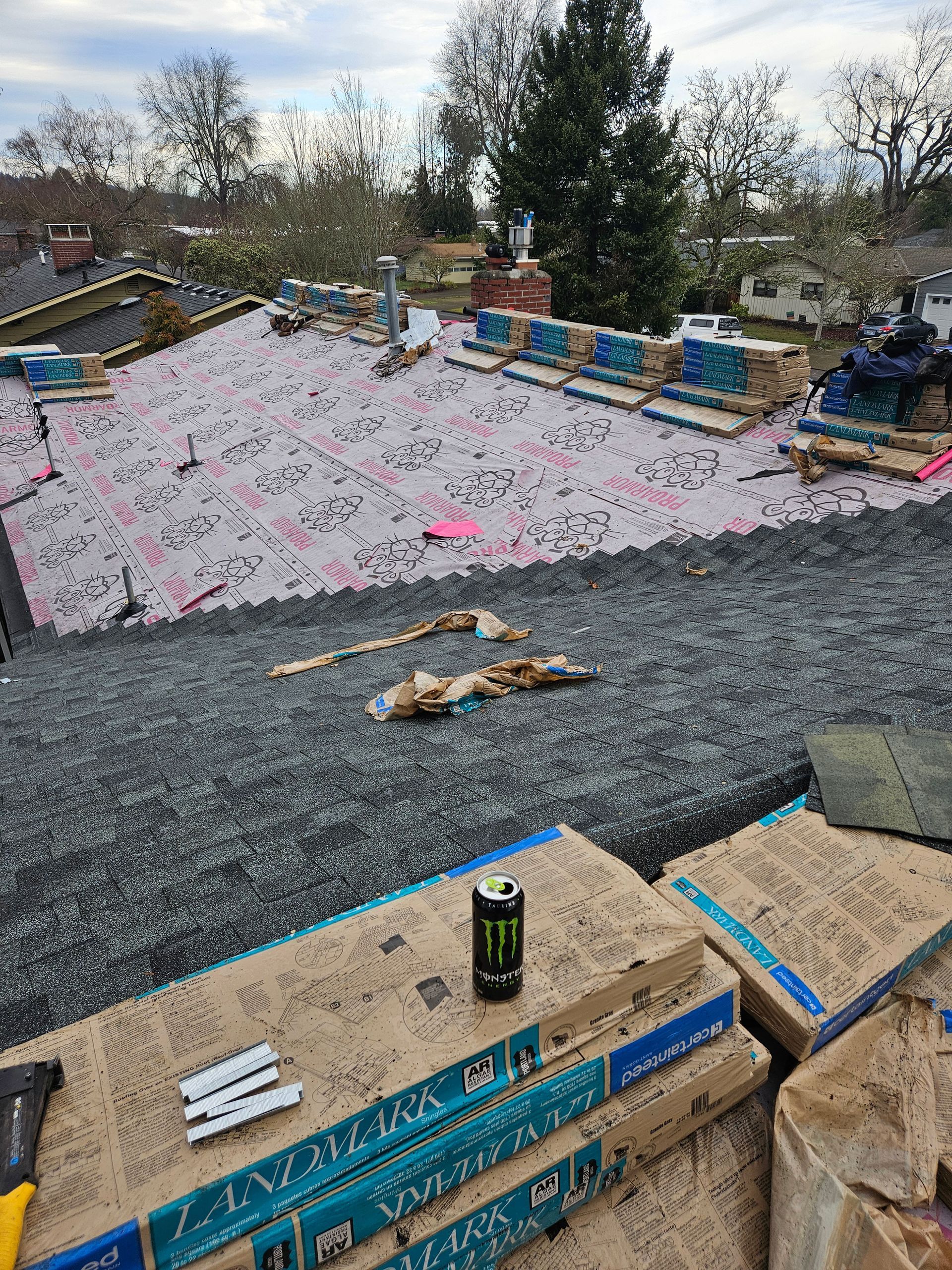 A can of monster energy drink is sitting on top of a pile of boxes on a roof.