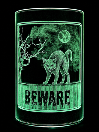 Green glowing candle holder with a snarling cat under a moon and the word “BEWARE” on the front