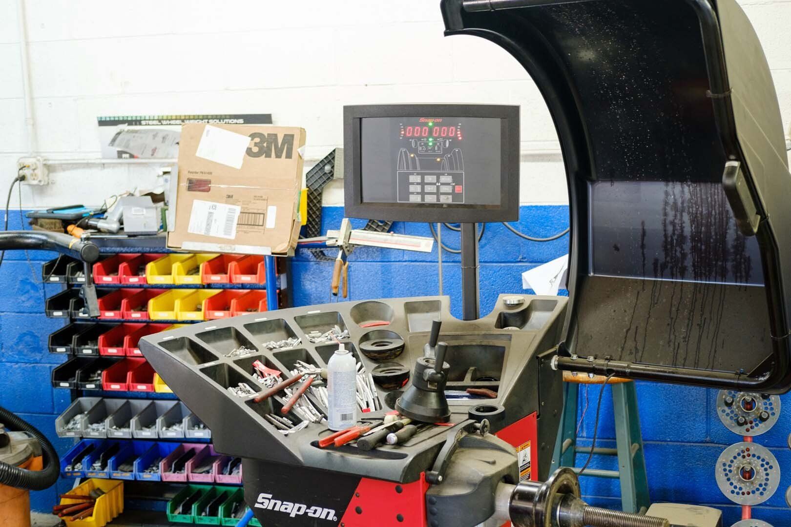 Wheel balancing machine with a digital display in an auto shop.