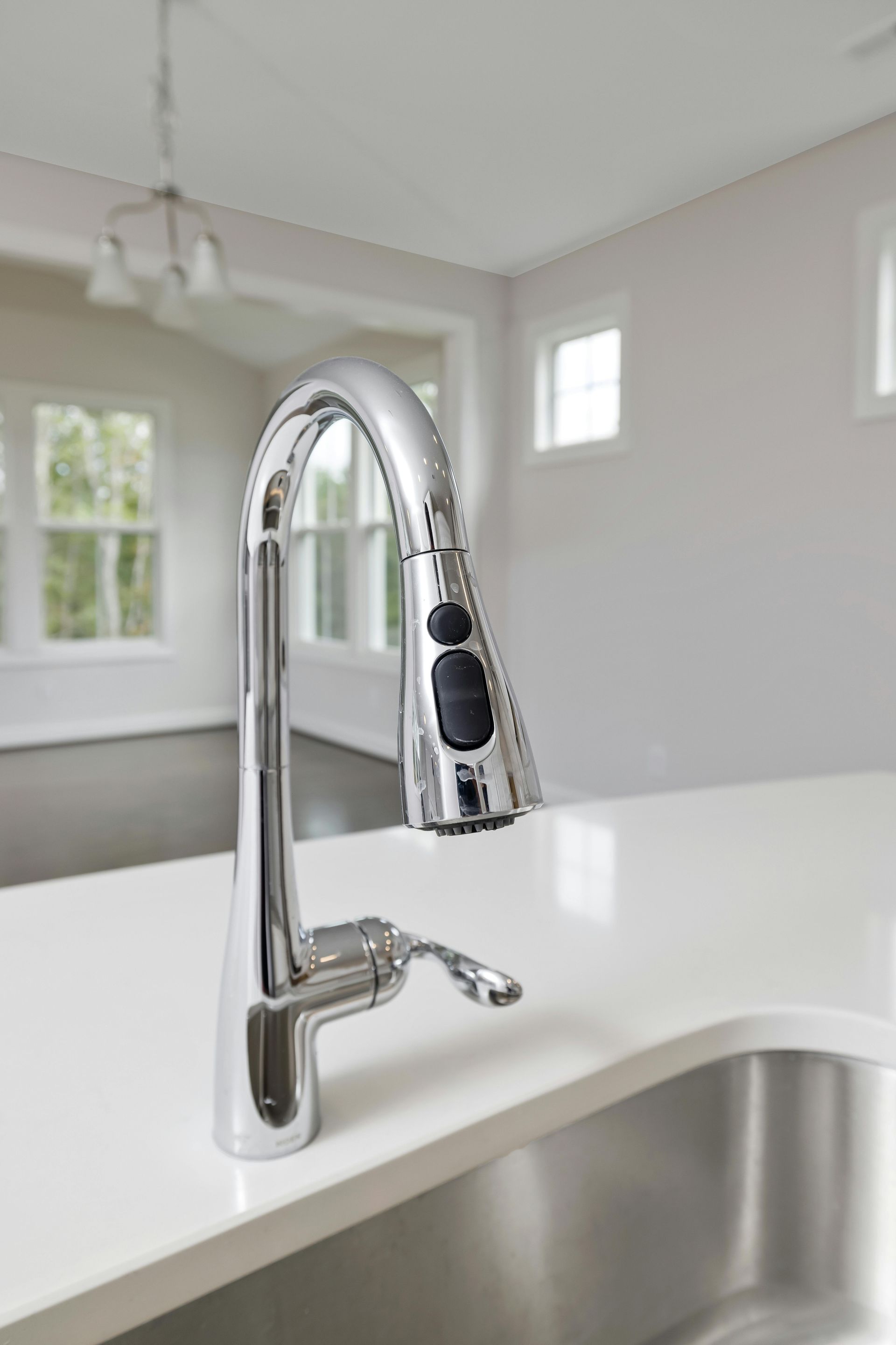 A kitchen sink with a chrome faucet on top of it.