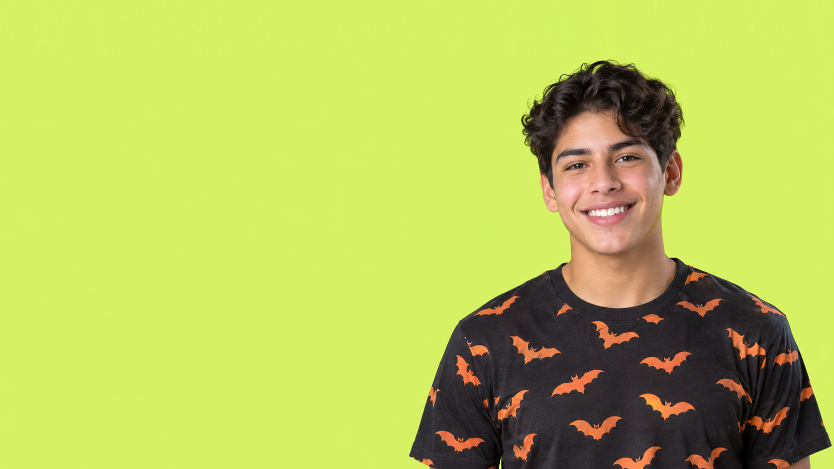 Smiling person in a black shirt with orange bats against a bright lime-green background
