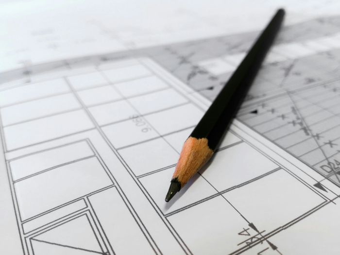 Design and Planning A pencil resting on an architectural drawing or blueprint.