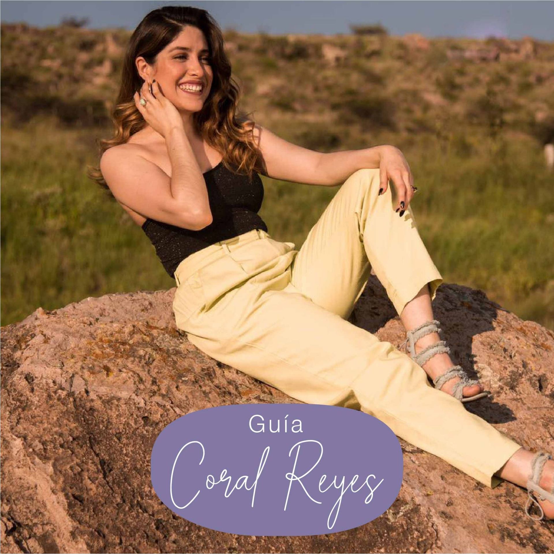 Woman in black top and yellow pants sits on a rock, smiling. Text overlay reads 