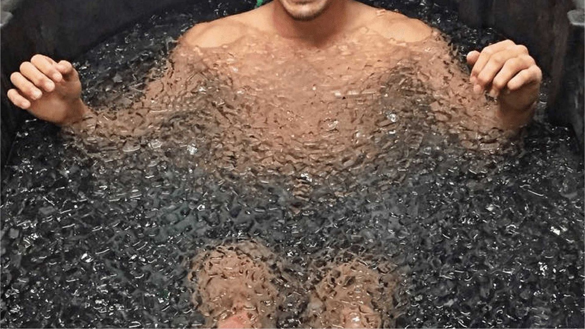 Hombre sumergido en un baño de hielo hasta el pecho.