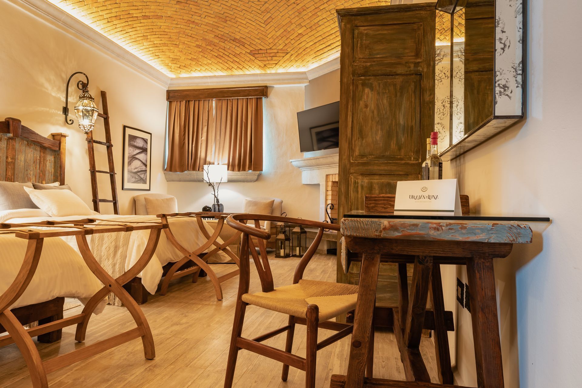 Bedroom with wooden furniture, including a desk and chairs, a bed, and an ornate ceiling.