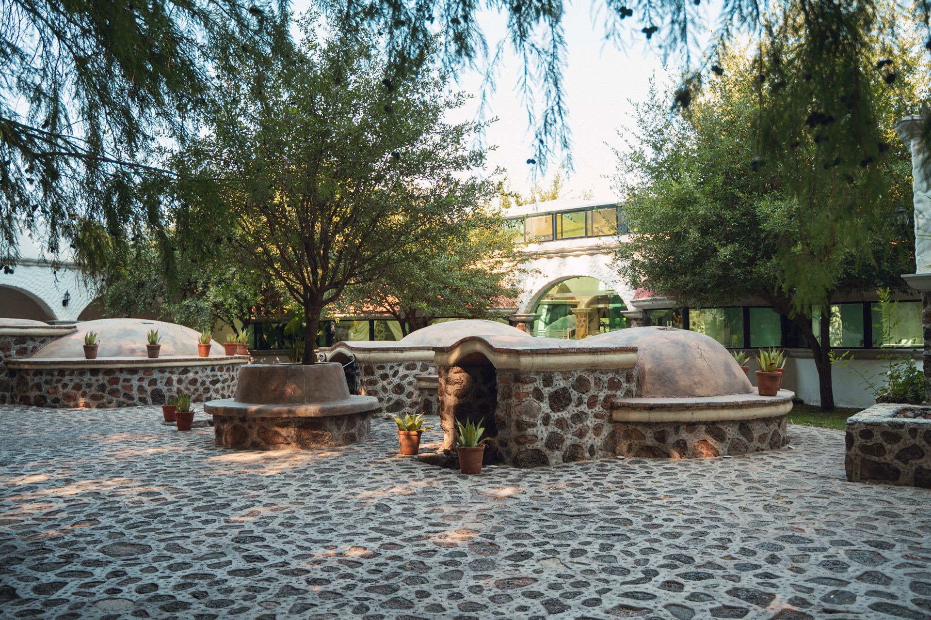 Patio con estructuras de piedra y árboles.