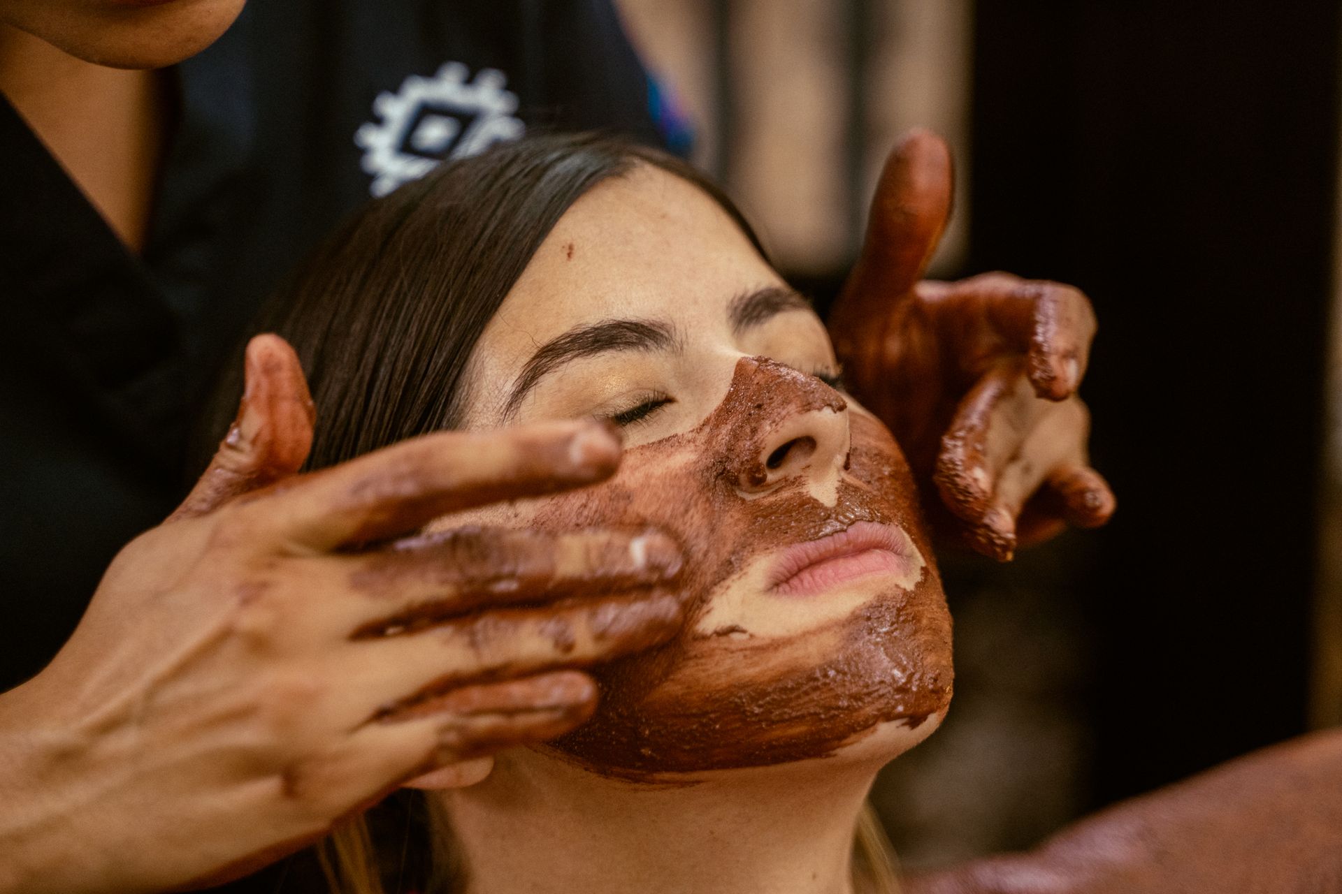 Persona recibiendo un tratamiento facial de chocolate en un spa.