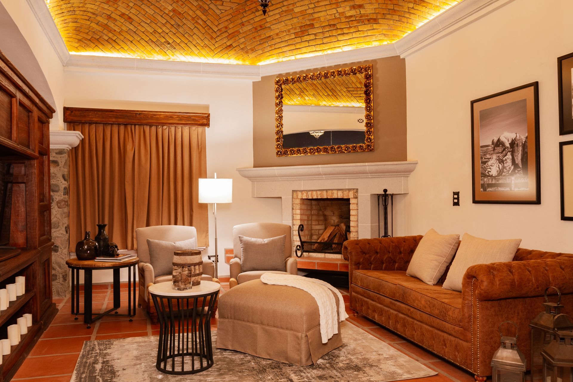 Cozy living room with fireplace, sofa, chairs, and ornate ceiling. Warm tones, elegant decor.