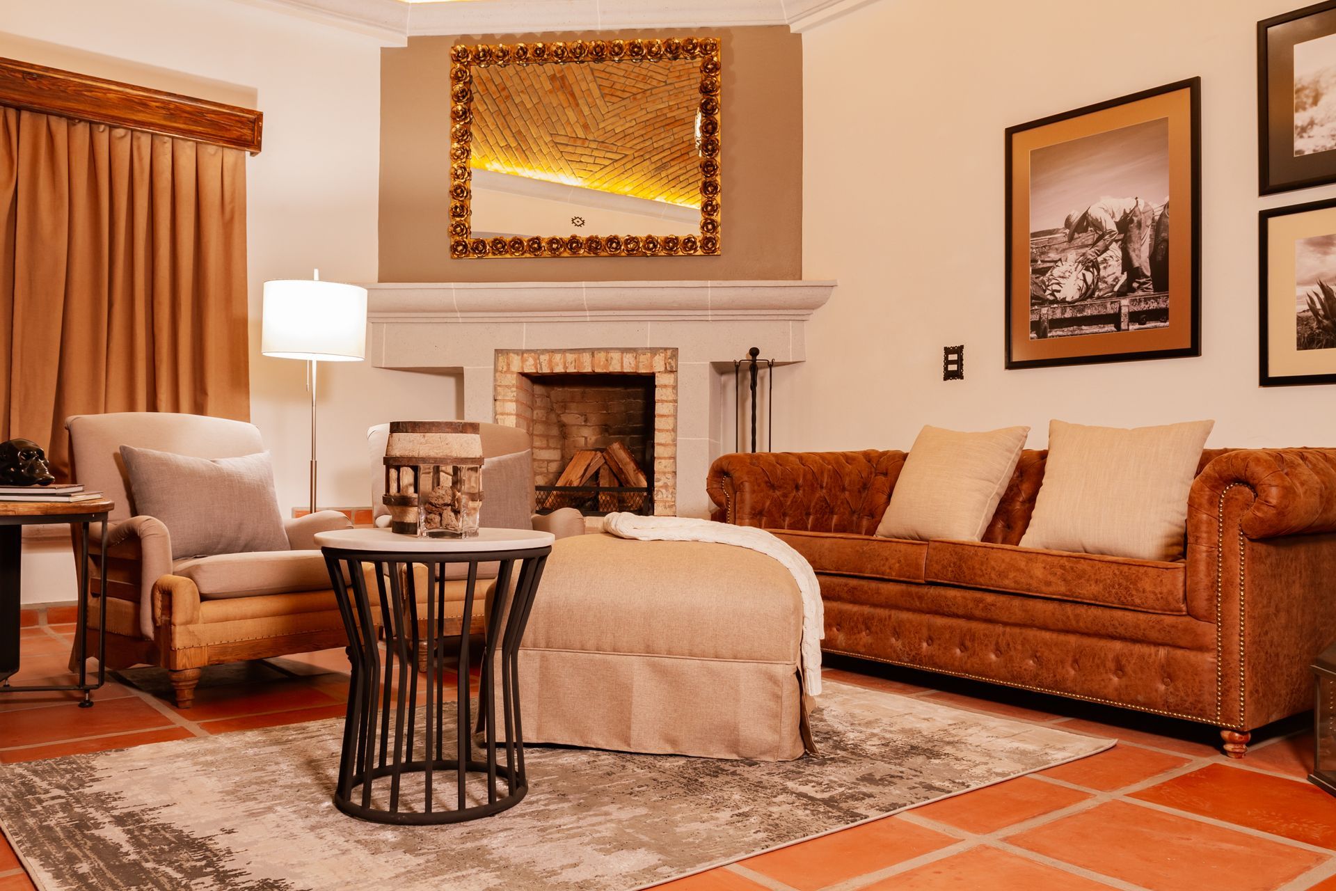 Living room with fireplace, leather sofa, armchair, rug, and decorative mirror.
