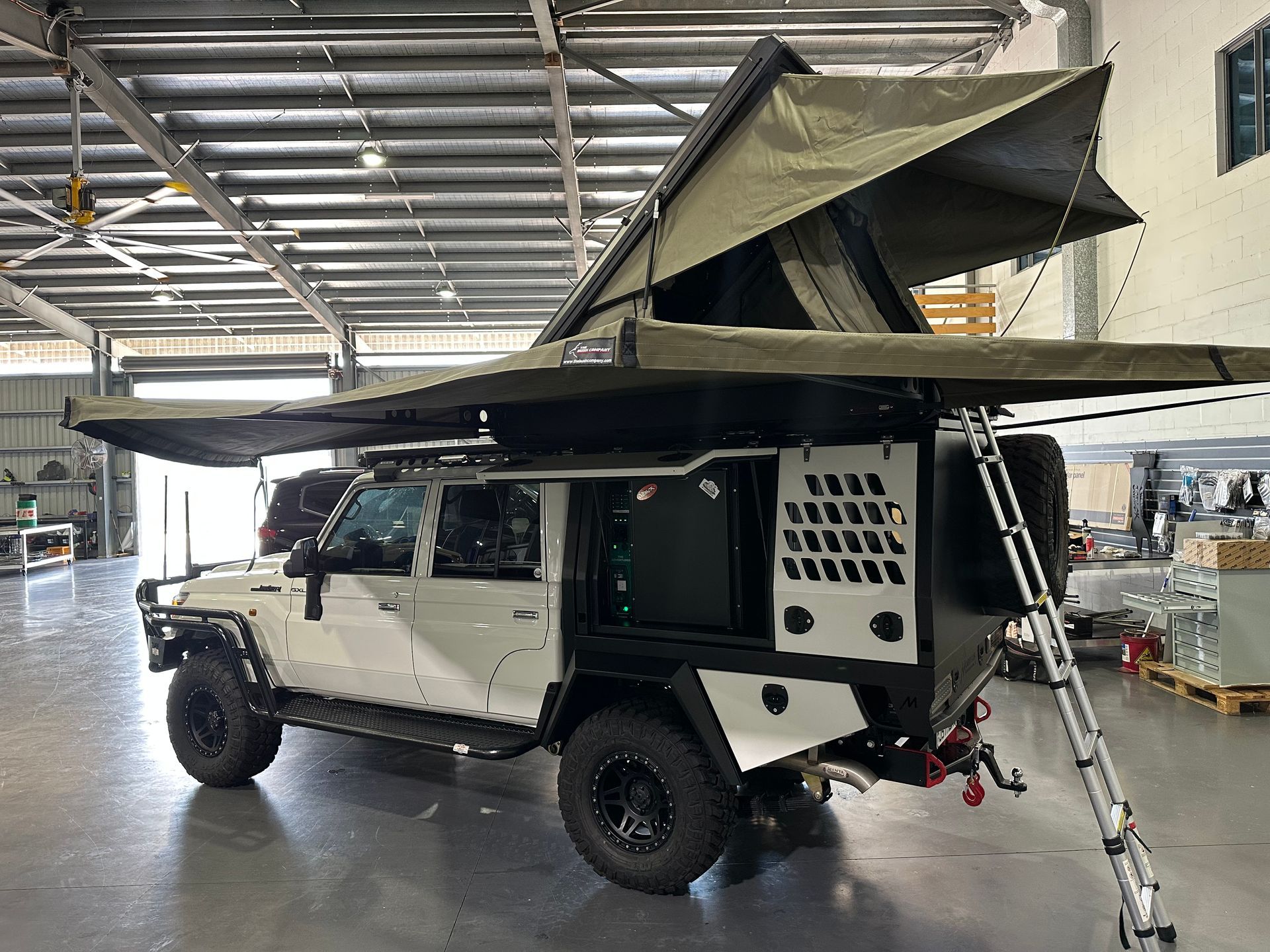 Off-road camper truck with pop-up roof tent parked indoors in a workshop  — Outback Auto NT in Berrimah, NT